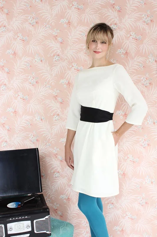PEONY Colette This elegant bateau neck sheath dress is simple to sew, with added interest from a fully removable cummerbund style belt which can be made in a matching or contrasting fabric, closing with a single button in back. Version 1 has 3/4 length sleeves, a contrasting belt, and in seam pockets. Version 2 has short sleeves, a matching belt, and no pockets.