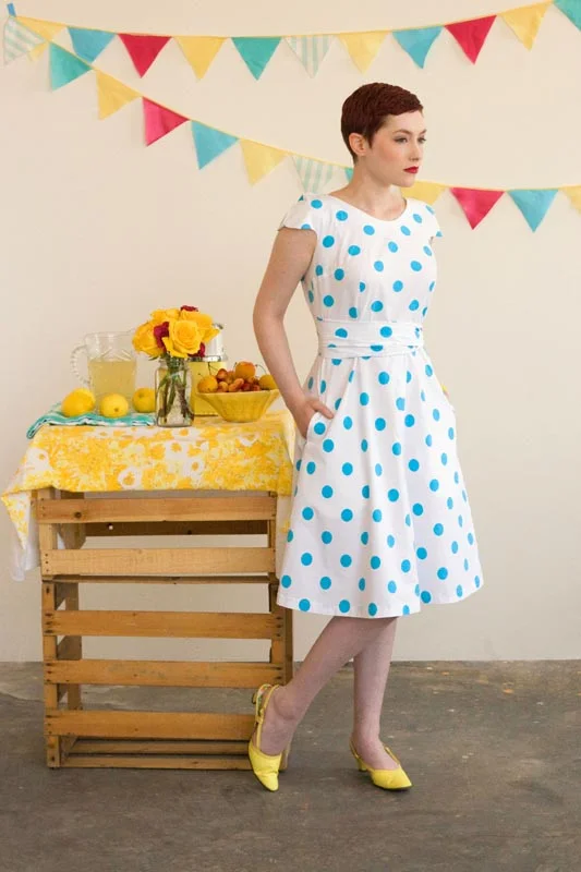 CREPE Colette A sweet and easy wrap dress with no closures to sew. The dress wraps in back and has cap sleeves. The wide ties encircle the waist for a comfortable dress with a fitted look. Version 1 has a rounded neckline, while Version 2 has a shaped sweetheart neckline and waist ties in a contrasting fabric. 