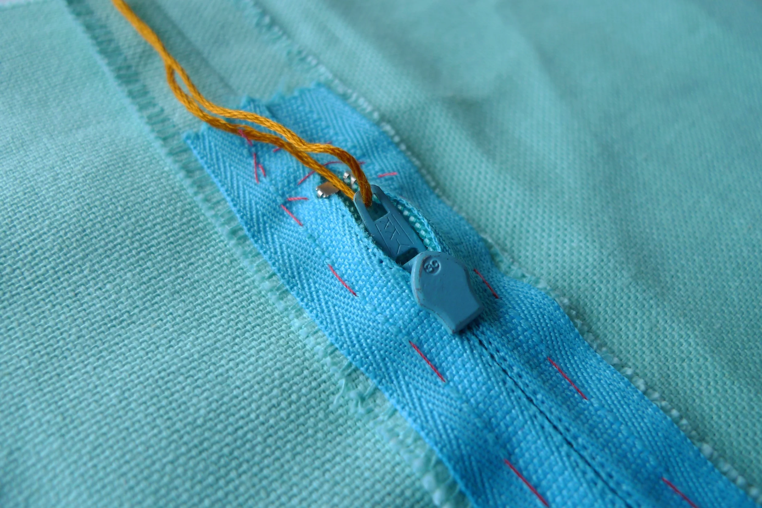 Embroidery thread tied to zip pull