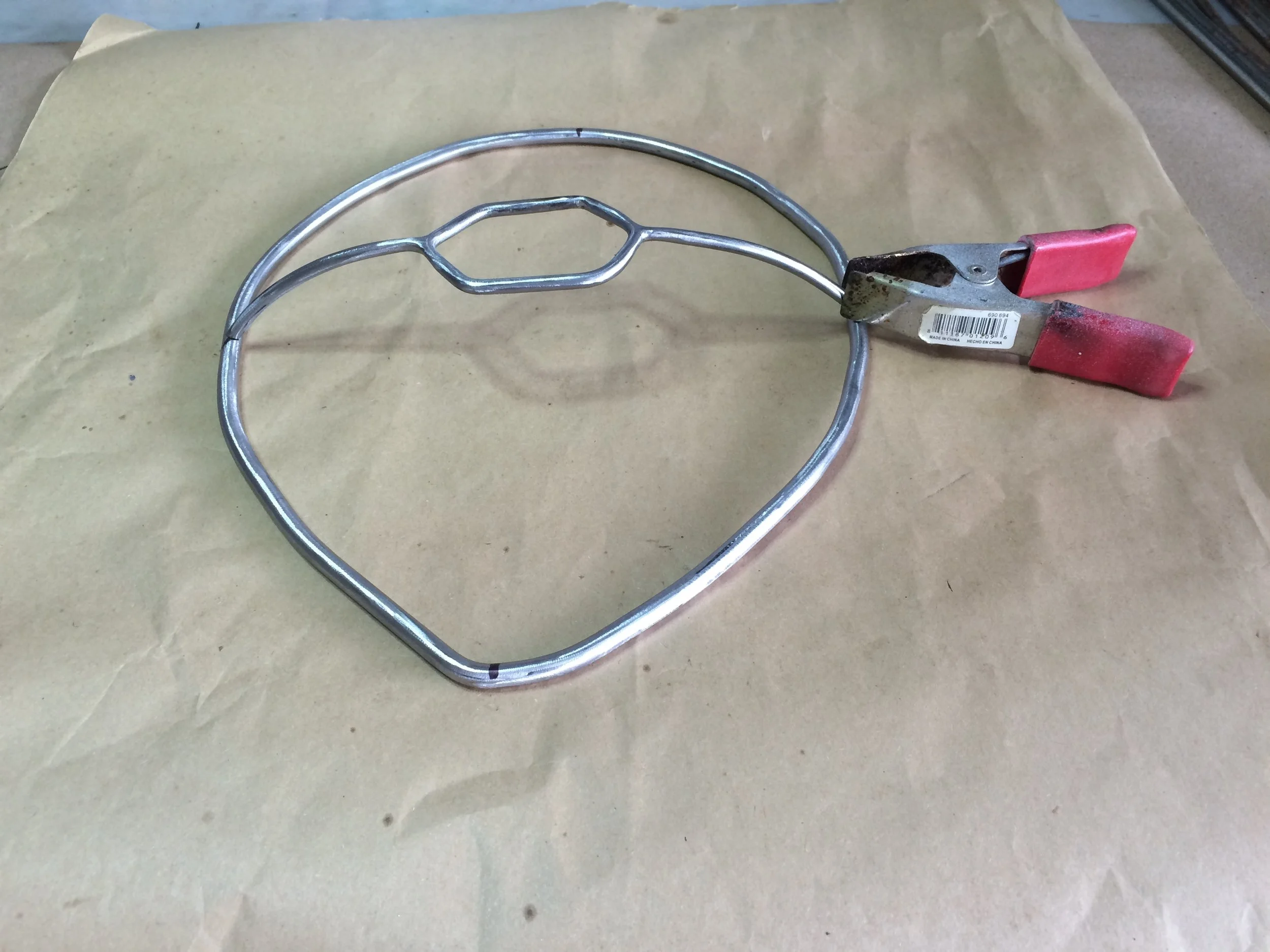 Here I've welded another piece onto the center loop and have the sub-assembly temporarily clamped to the frame to gauge the arc and height. .