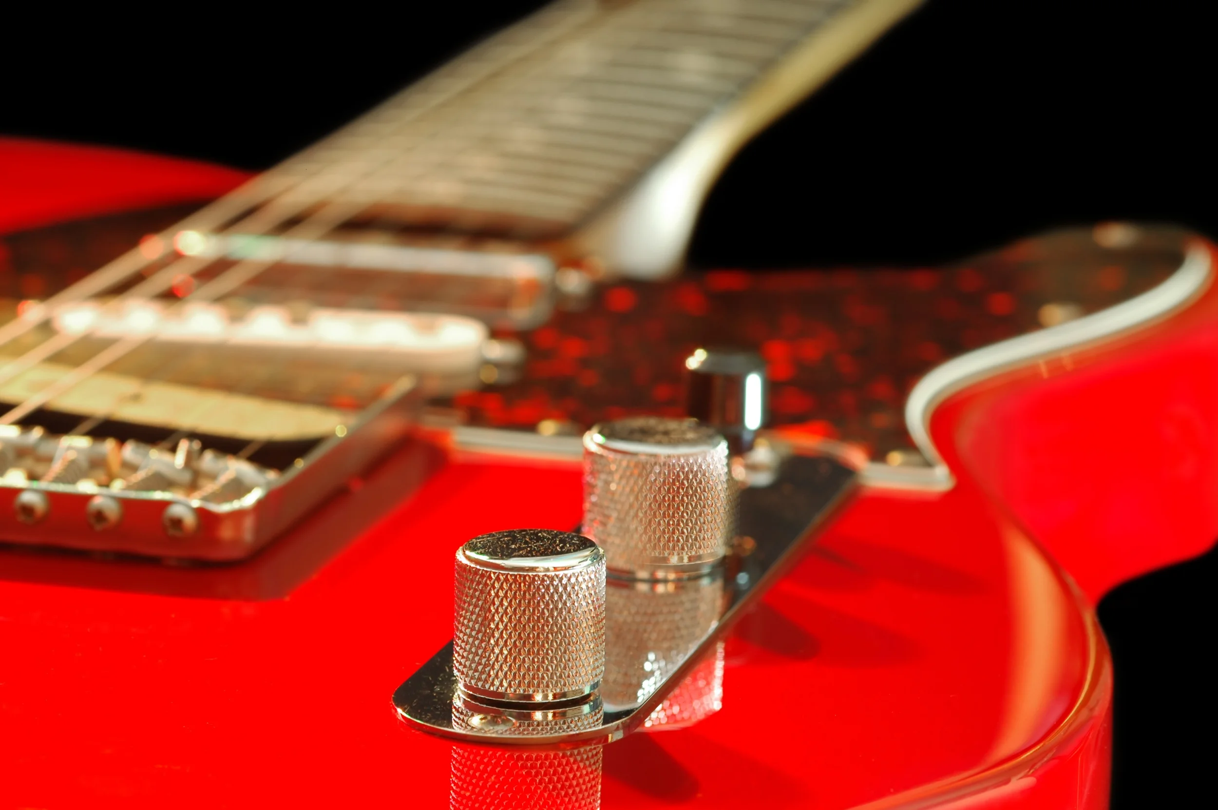 Close-up of the control knobs on a red electric guitar | Boulder Guitar Coach