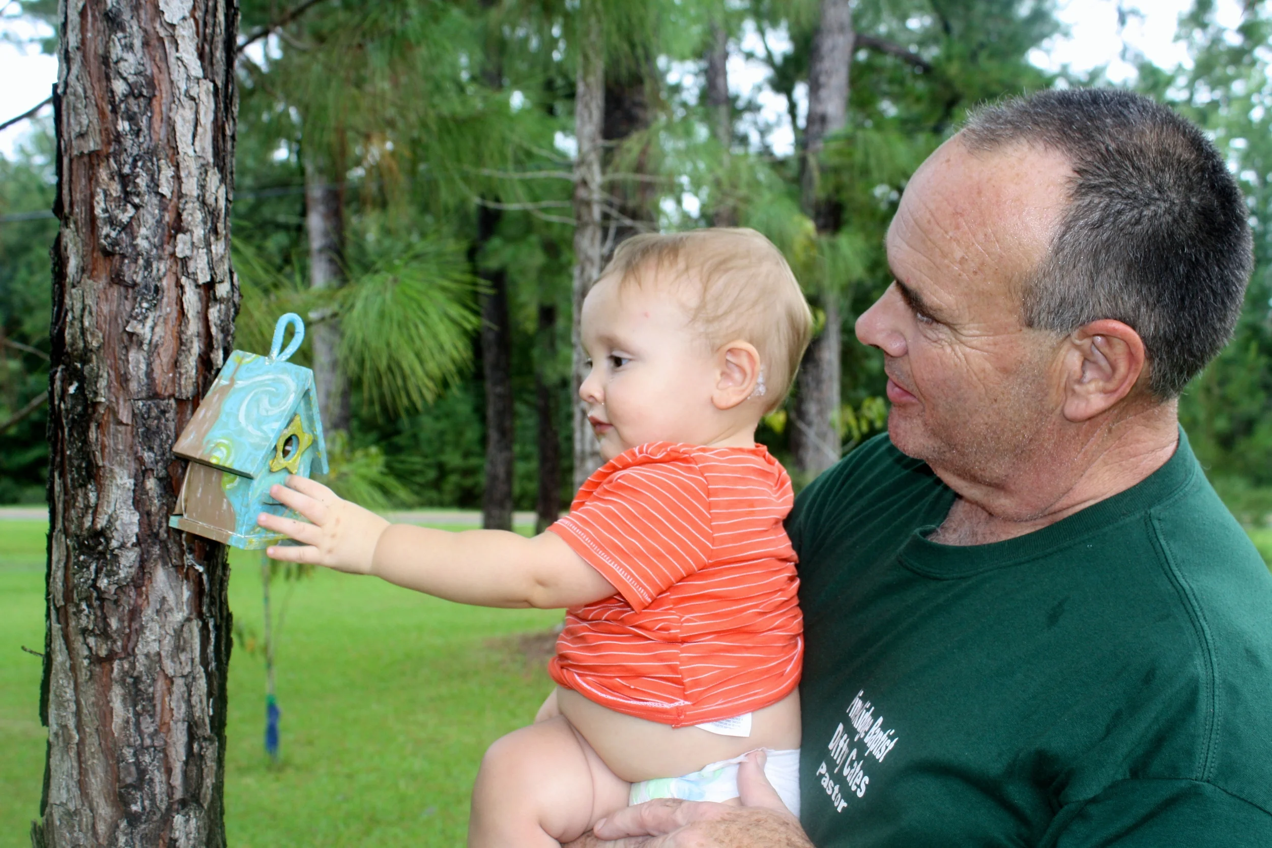 Judah with his grandad checking out the birdfeeder I painted last spring break.