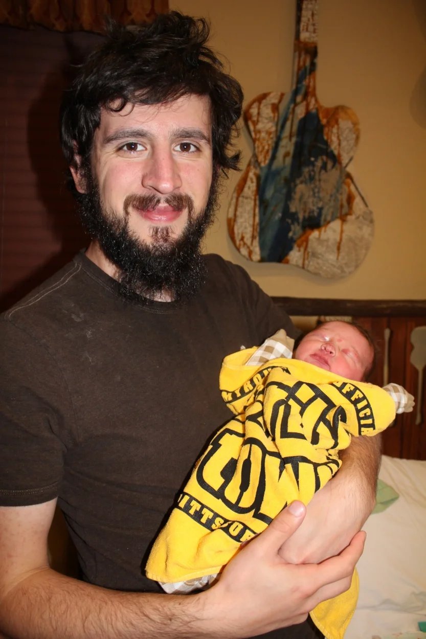 Joshua with second-born, Judah in the "Music Room" (hence the guitar art!). 