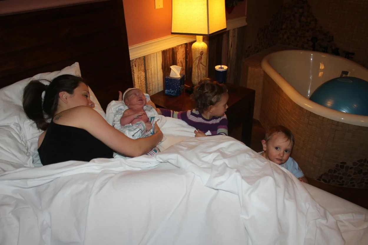 Kenzie and Judah meeting Olivia (third-born) for the first time. She and Cora share a birthing room.