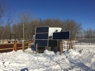 Solar panels supply energy to charge batteries for the water pump.
