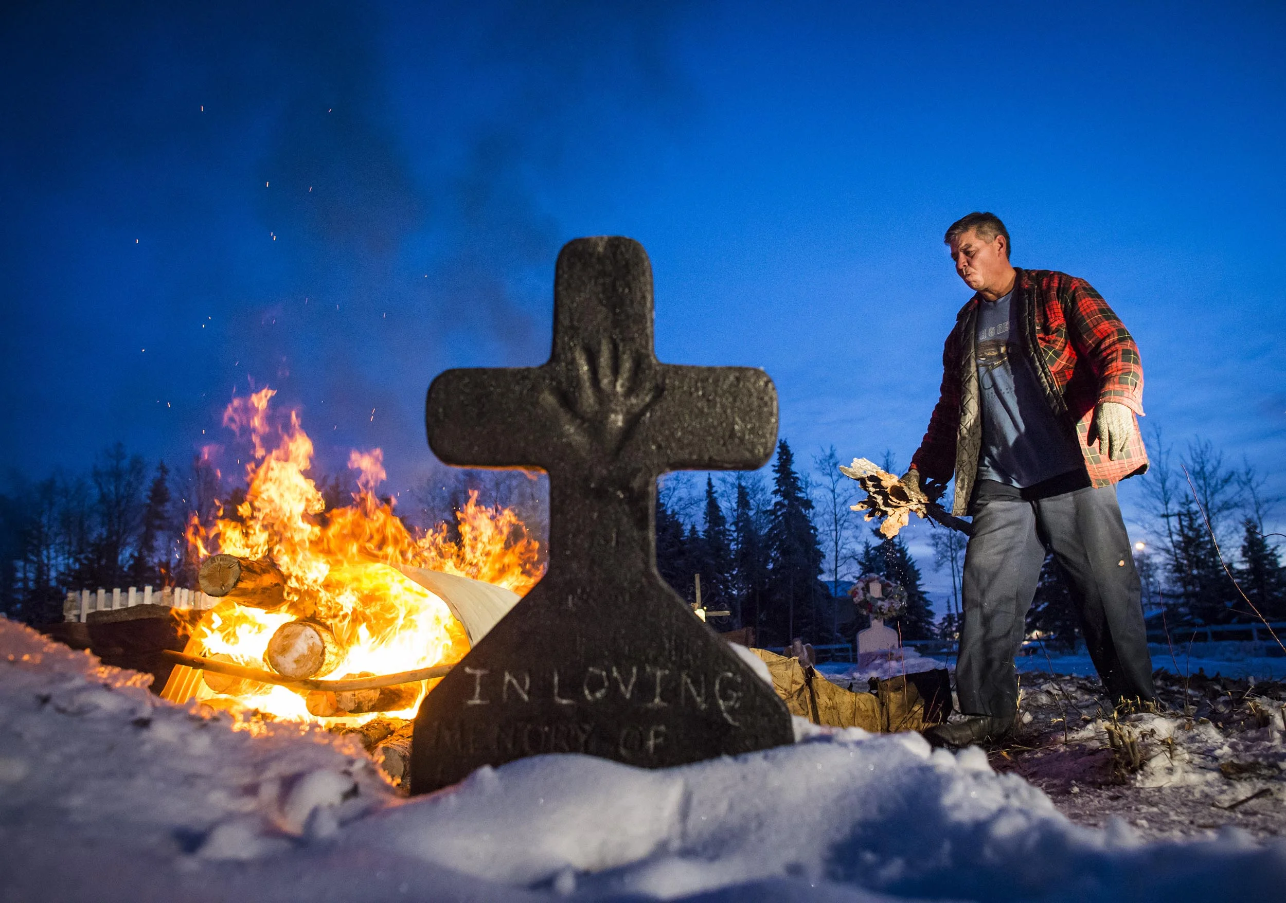  Cliff Toulejour feeds a fire to soften the ground to dig the grave for his niece Marie Janvier January 26, 2016 in La Loche, Saskatchewan. Marie Janvier was shot and killed during mass shooting January 22 at the school where she worked. (John Lehman