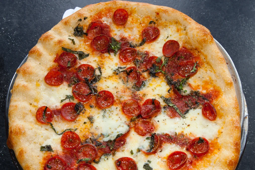 NEW YORK STYLE PIZZA Our Margherita pizza is made with fresh mozzarella, roasted Roma tomatoes, Pecorino Romano, olive oil, & fresh basil