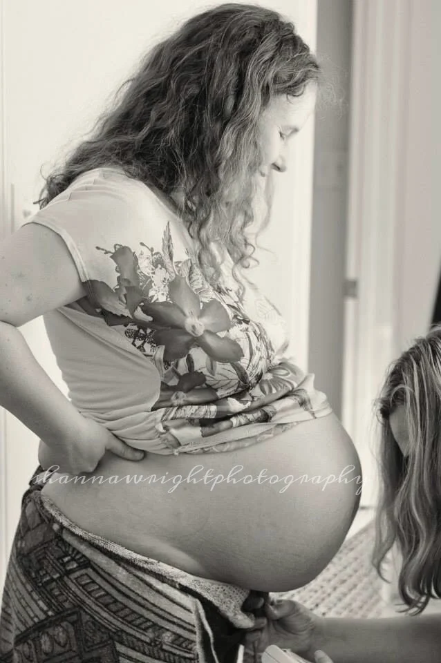 Midwife Liz listening to baby's heartbeat with a handheld doppler. Image provided by Shanna Wright Photography