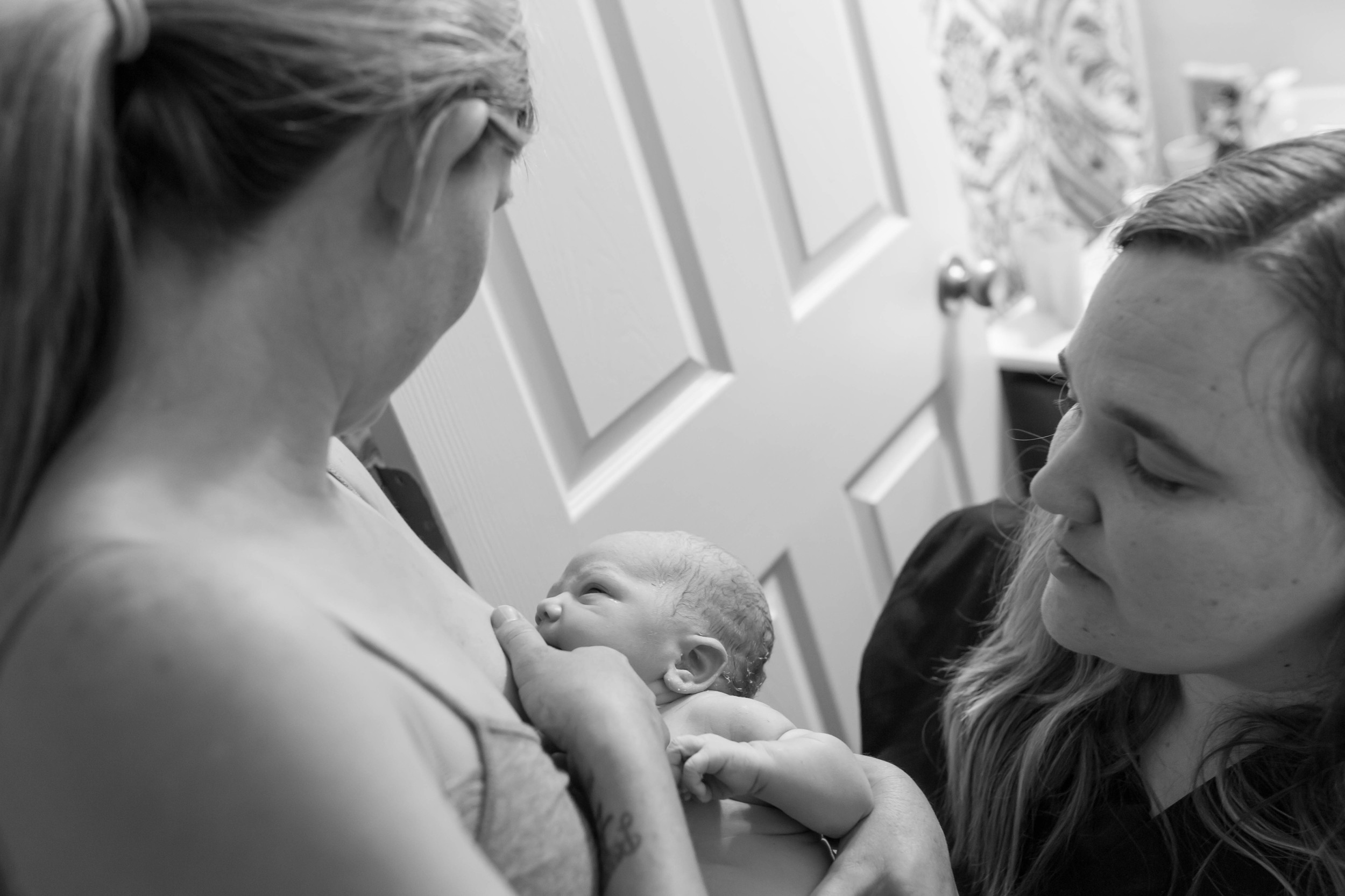 midwife, Liz Derry, checks on Mom and brand new baby. Image provided by Karina Schuh Photography.