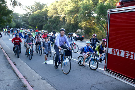 Former Manor School principal, Jason Richardson, leads a pack of kids to school on International Bike and Walk to School Day.