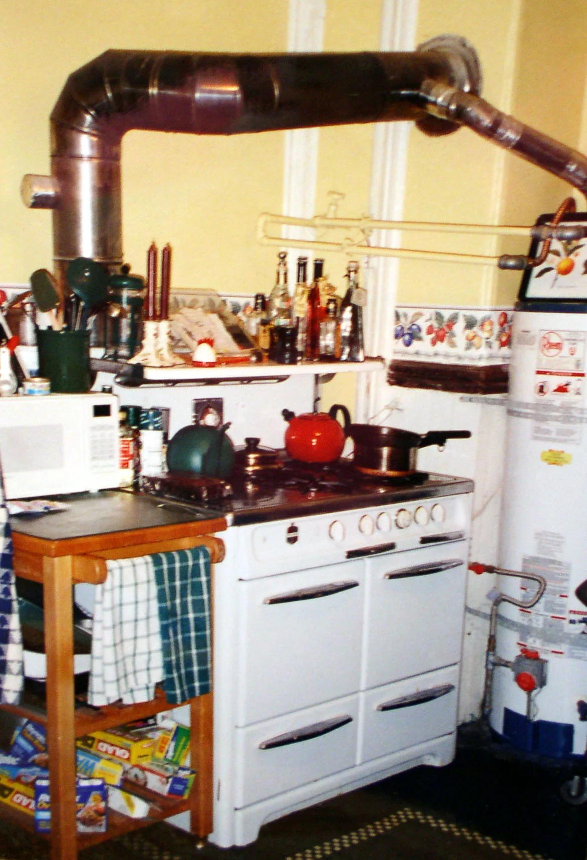 Before: Exposed water heater, huge exhaust pipe, rolling bar cart