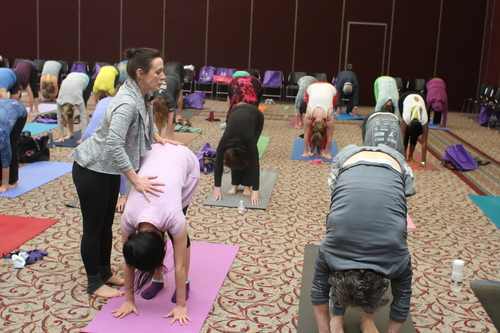 Nicole Nichols, owner of Republic of Yoga, giving a participant an adjustment.