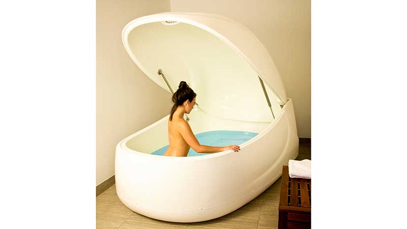 A woman prepares to float in an Evolution Float Pod at Lift/Next Level Floats in NYC.