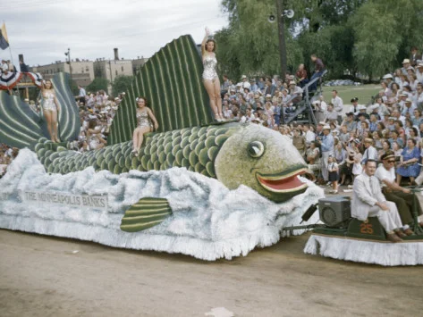 jack-fletcher-men-and-women-ride-on-fish-float-in-aquatennial-parade.jpg