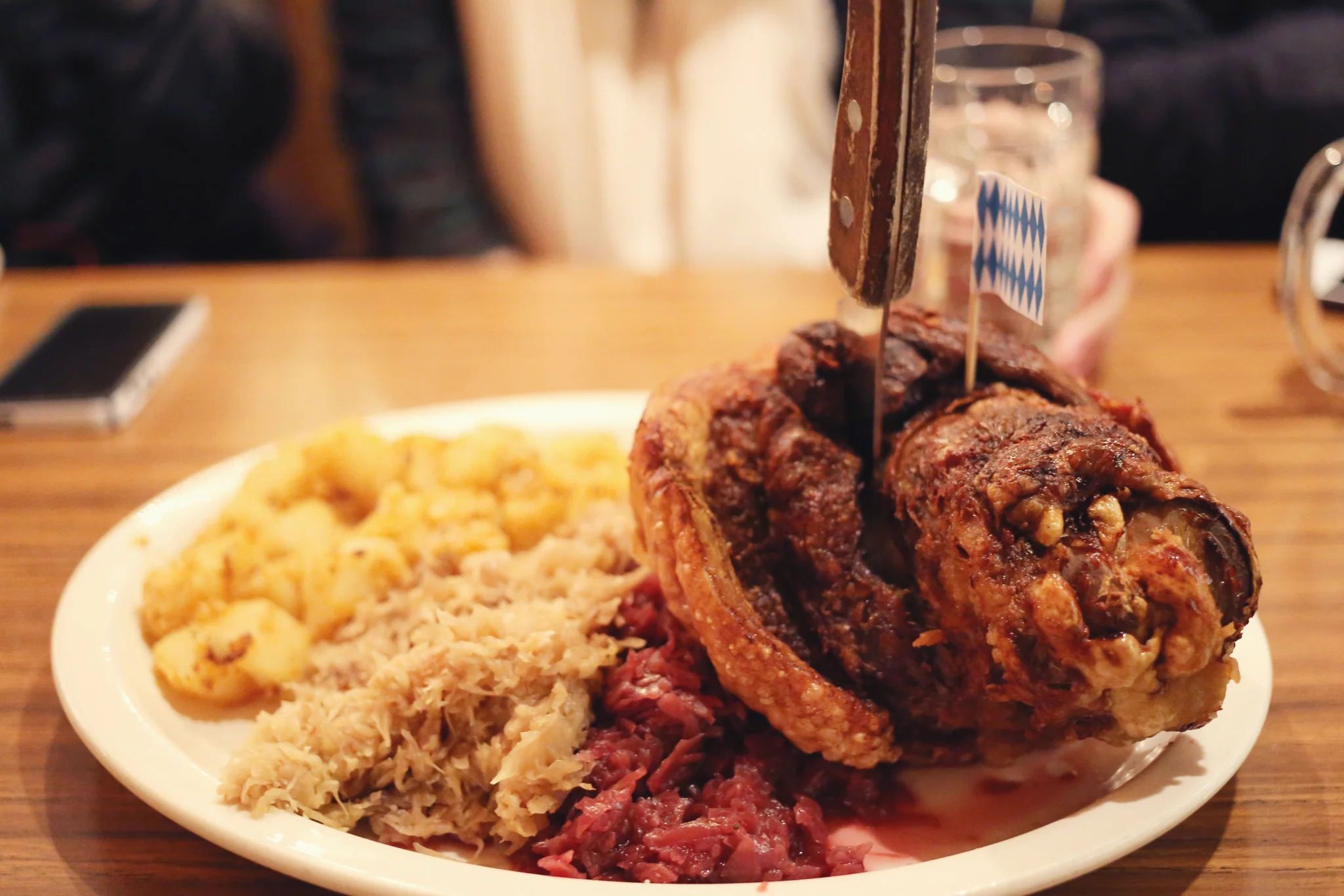Schweinshaxe A giant “Munich-Style” rotisserie-broiled pork hock, served with German-fried potatoes, Weinkraut and red cabbage.