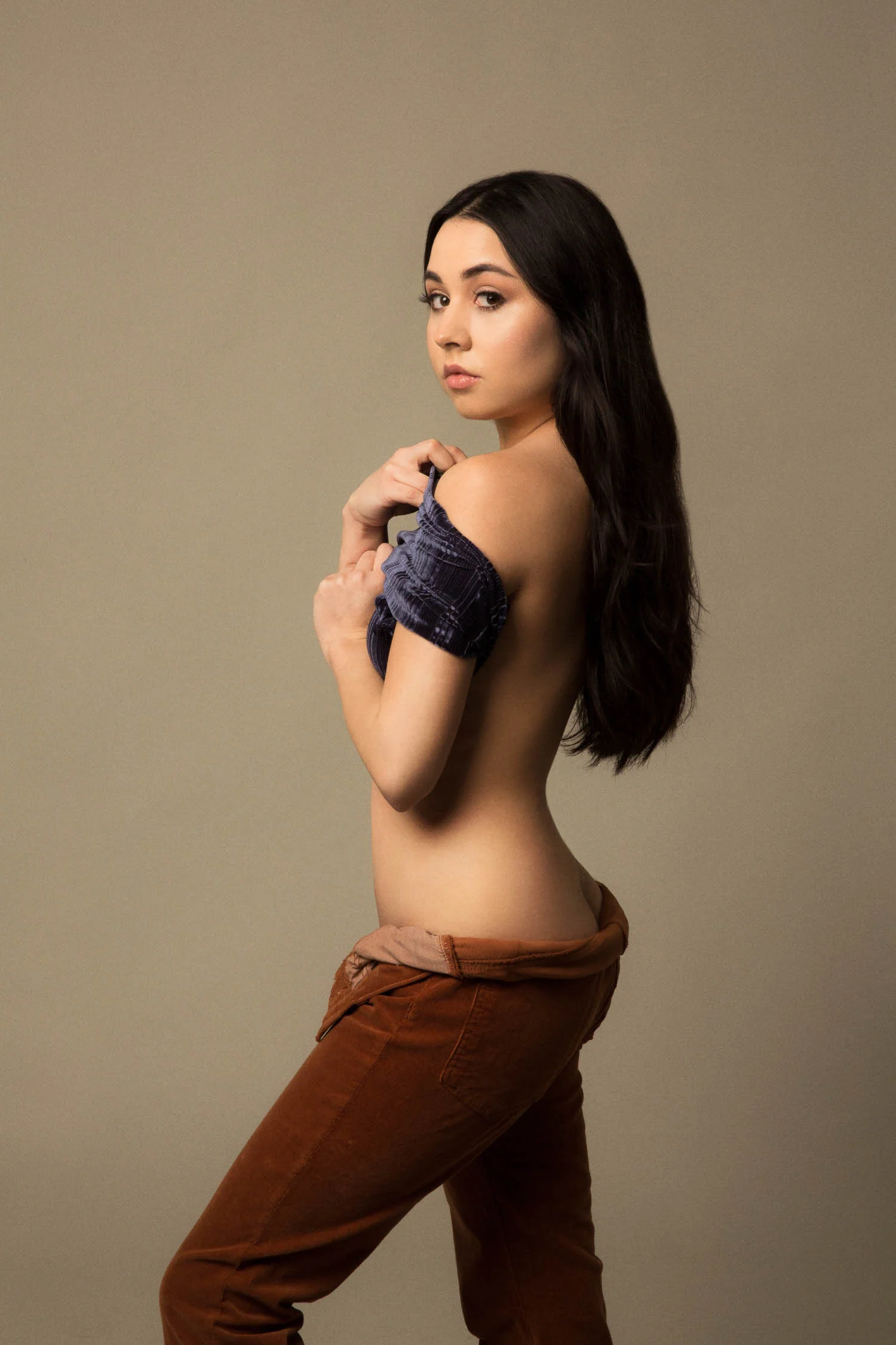 Woman with black hair wearing low cut corduroy pants