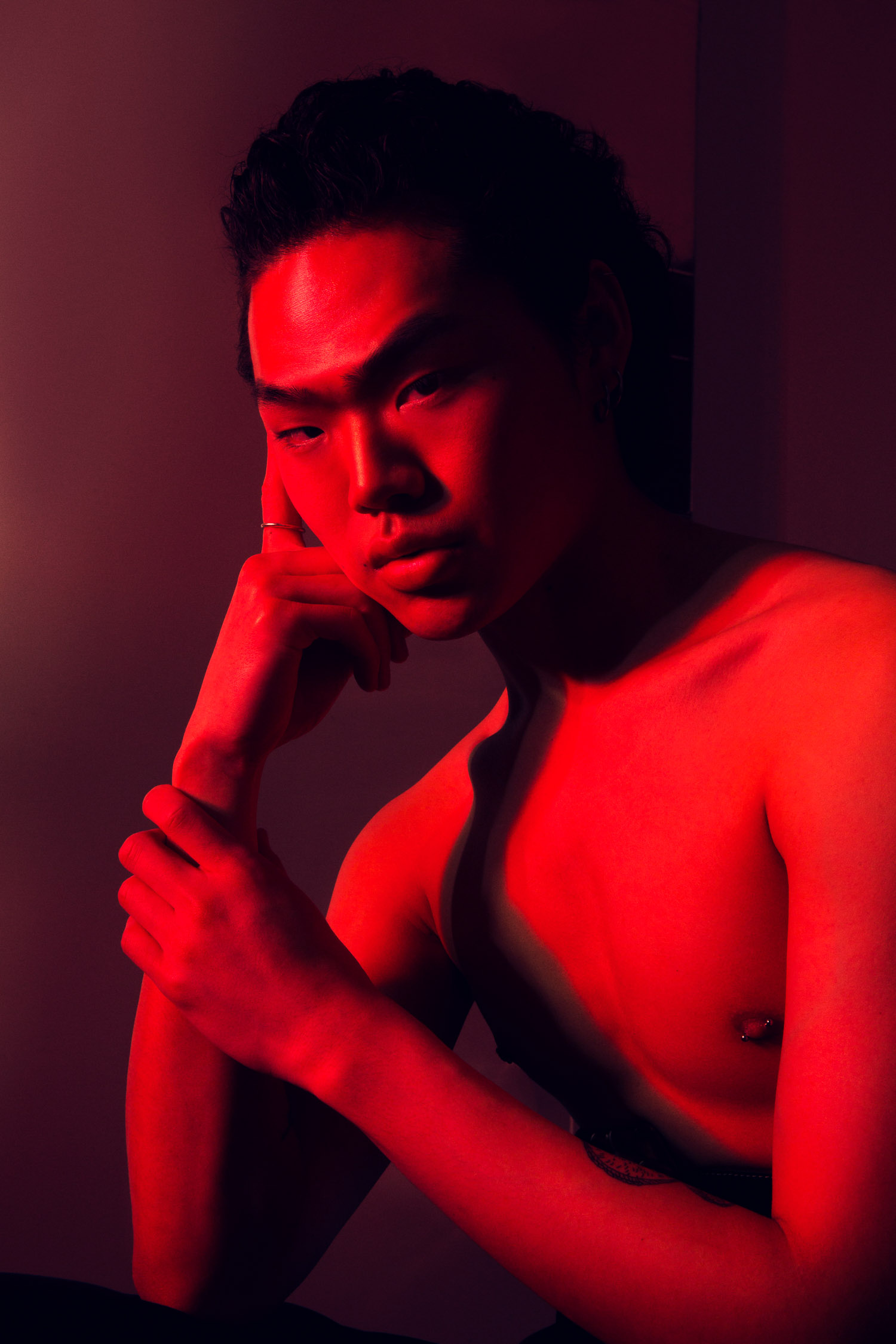 Red light closeup of asian male model.