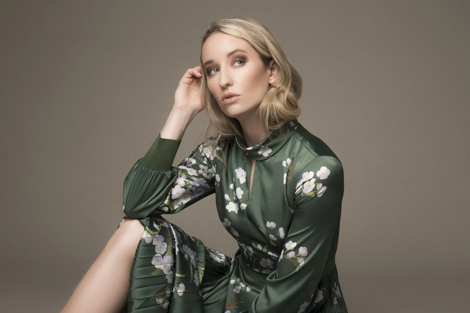 Woman sitting in a green Ted Baker dress