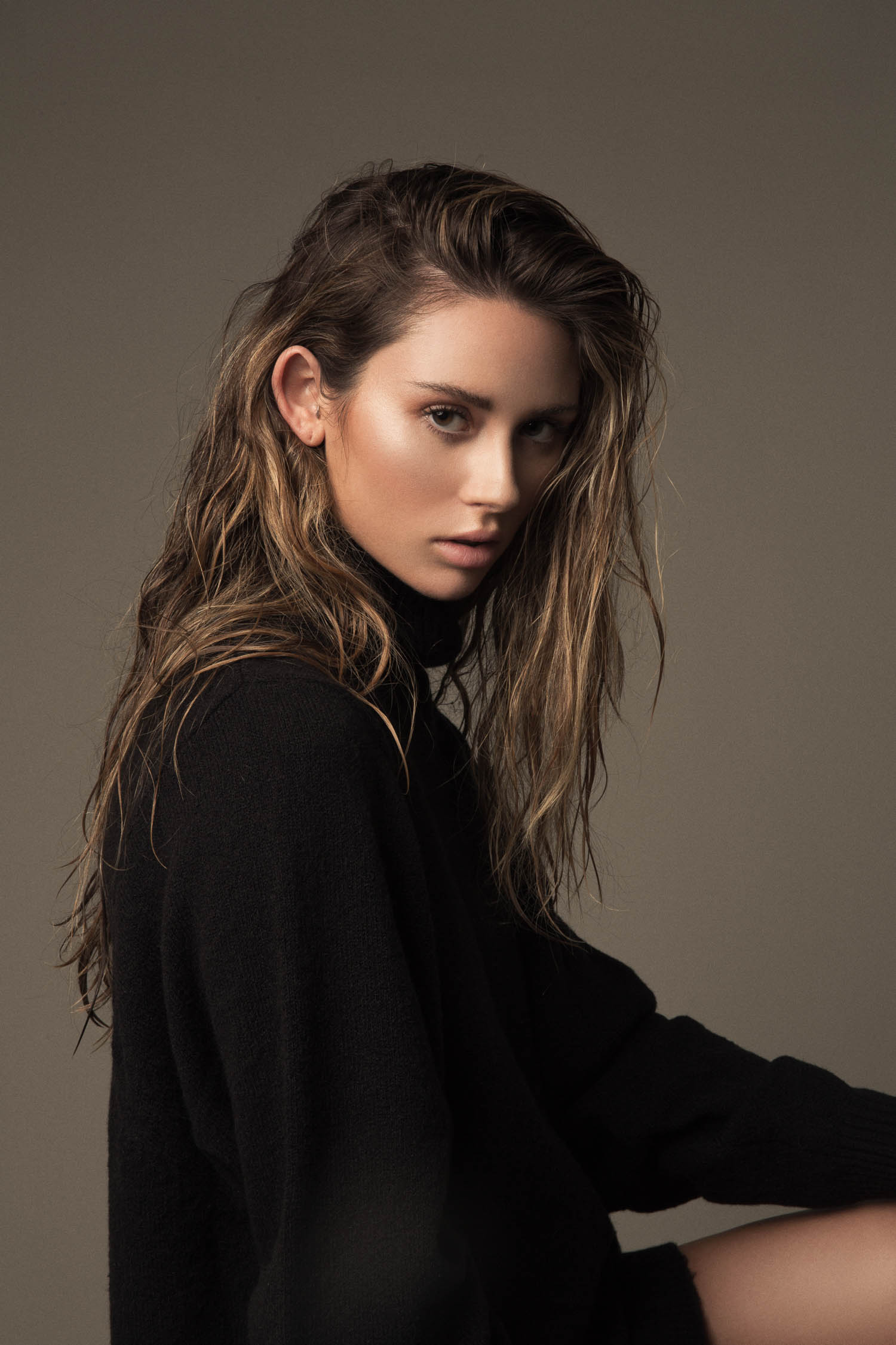 Model with wet hair wearing a black turtleneck