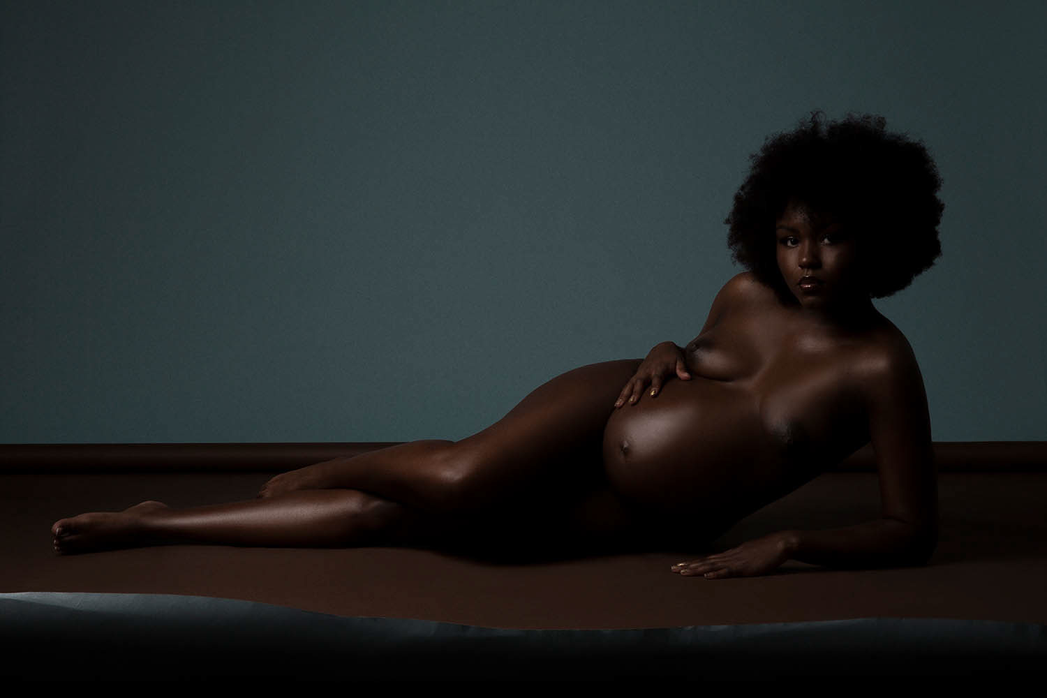 Black model posing for maternity portraits