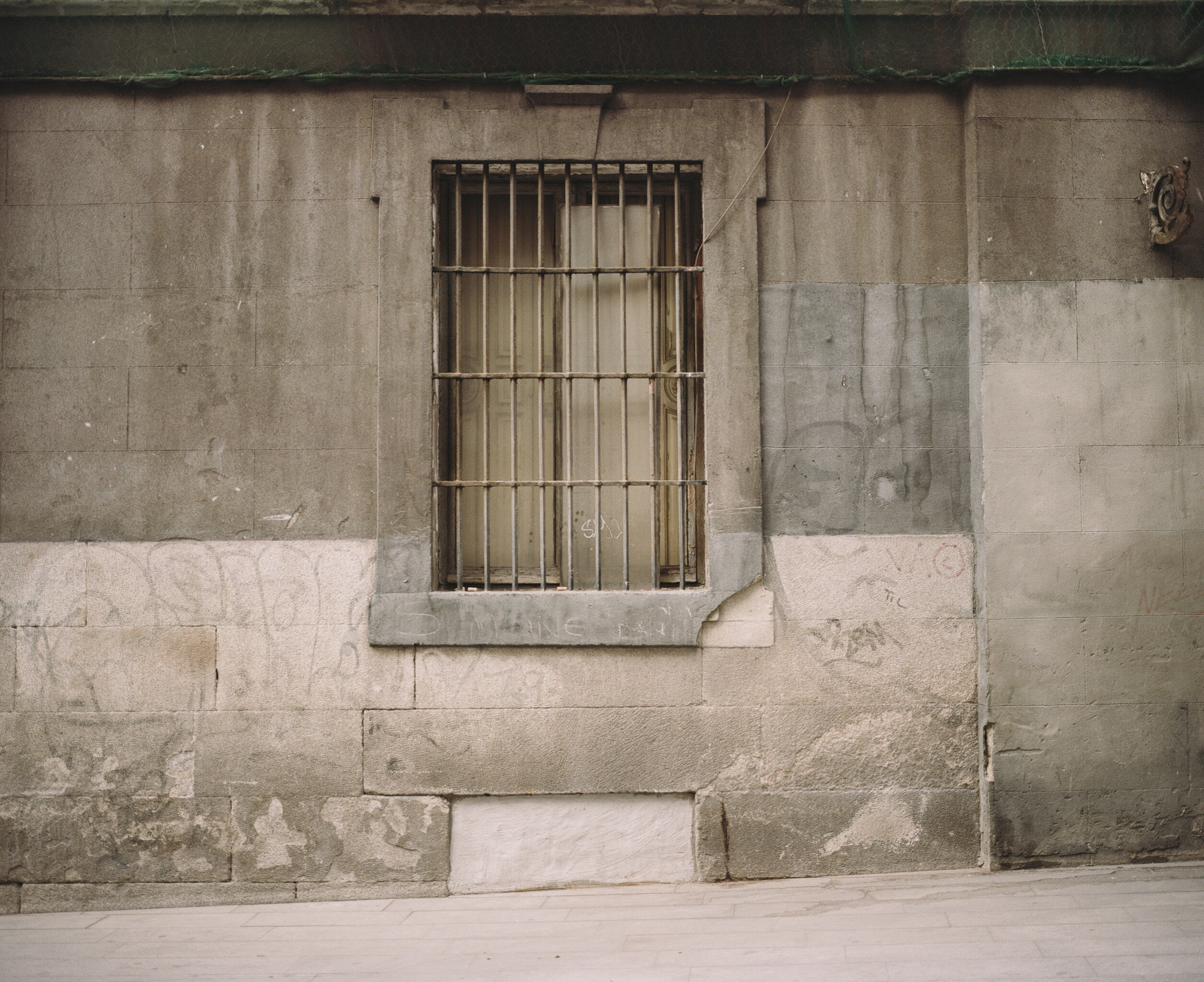 Window with bars on a grey wall, Europe