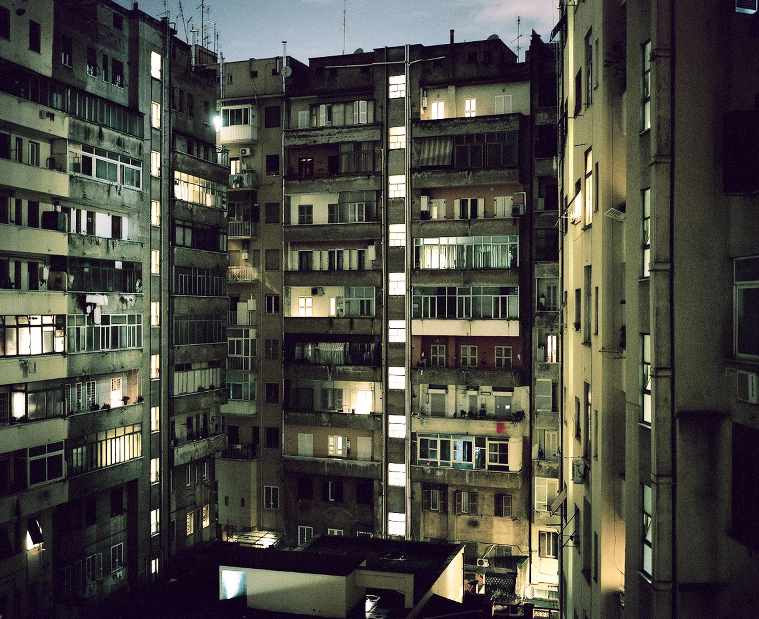 Windows at night in Rome building courtyard