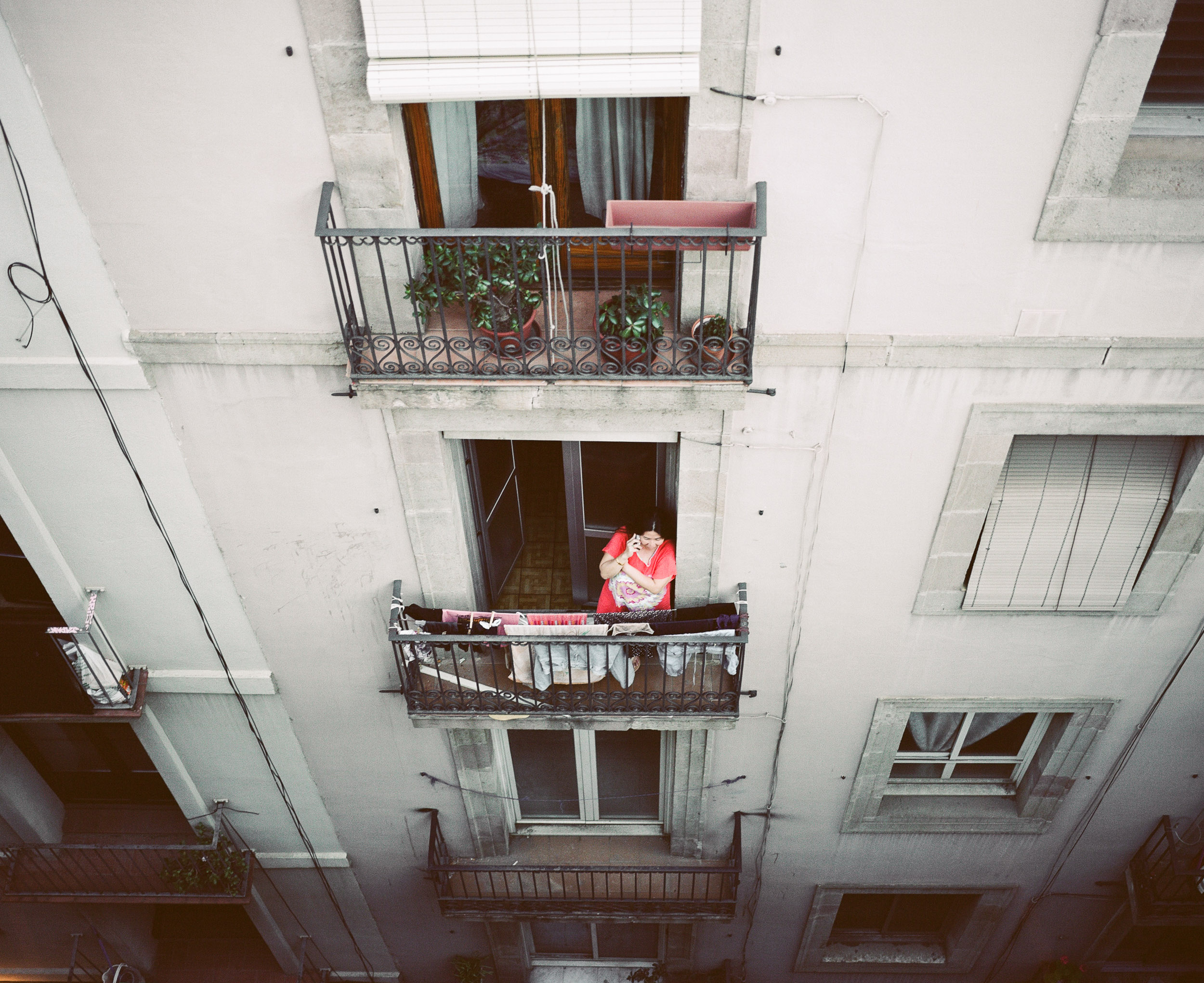 Woman on the phone standing on a balcony in Barcelona, Spain