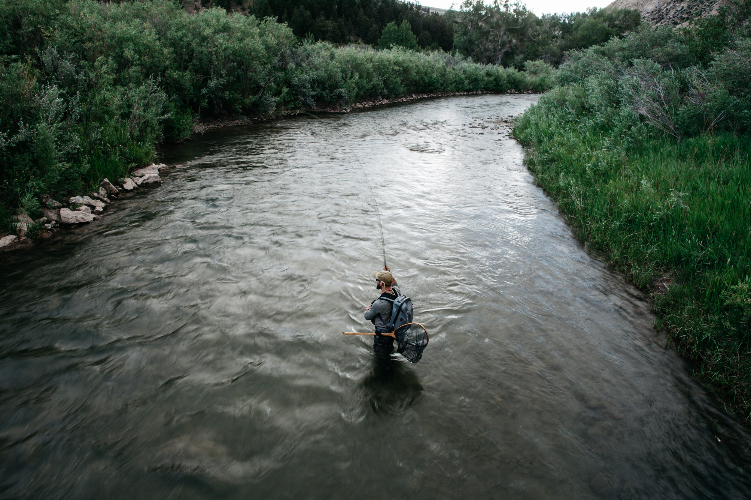 Fisherman in a river at dusk in the summer