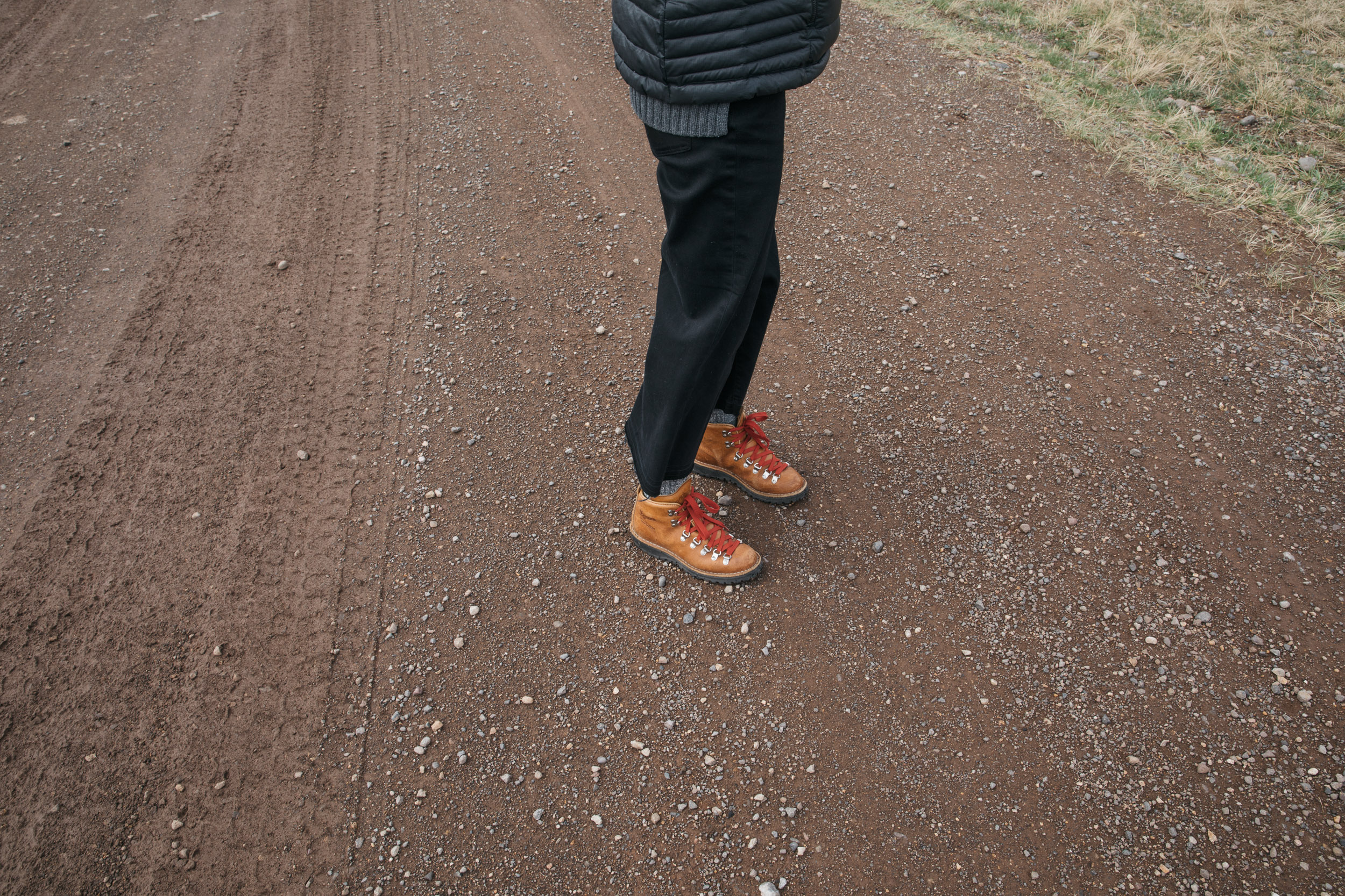 Danner boots with red laces on a woman standing on a red dirt road in Montana