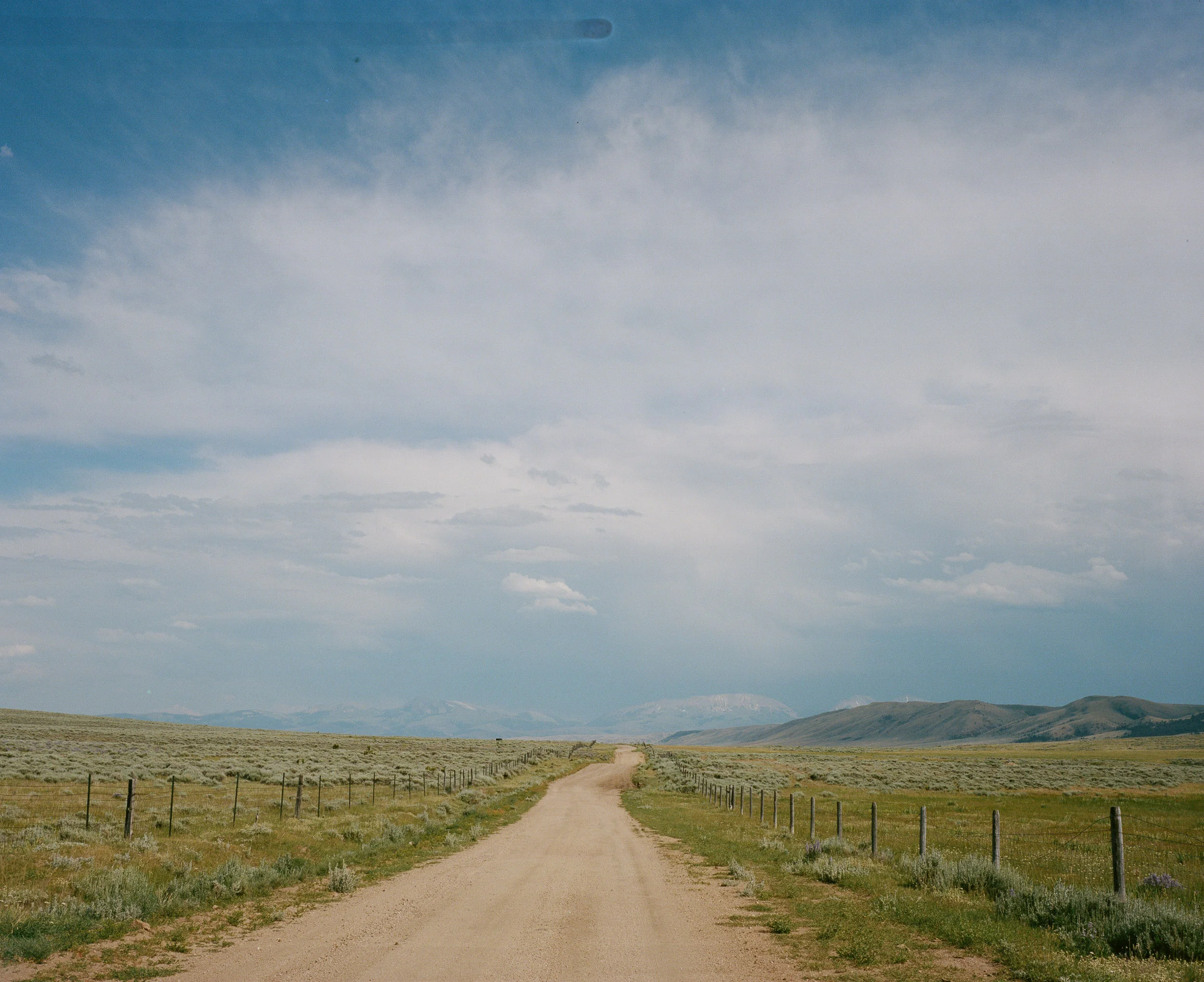 Long backroad in the country with mountains in the distance