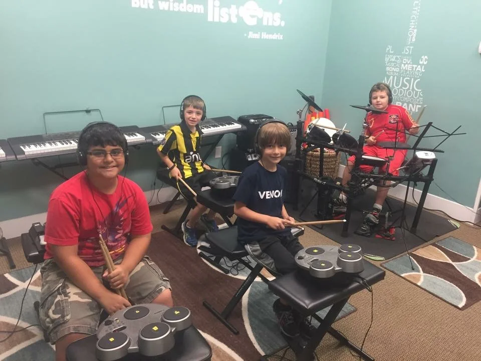 Small group drumming classes allow us to learn paradiddles, singles, doubles and drum reading on drum technique pads and then transition to playing on a roland professional set.