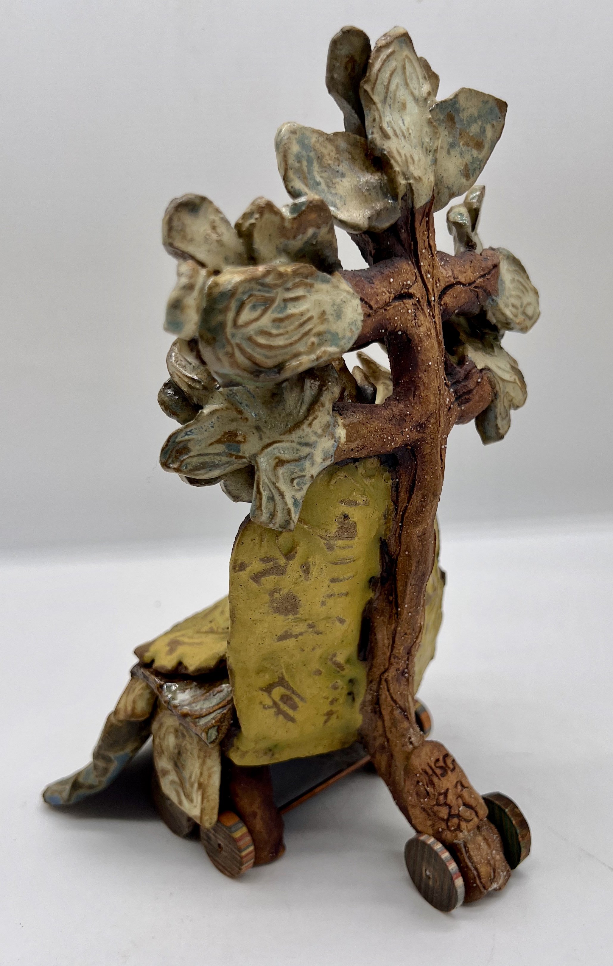 Wializen. Side /Back View. Ceramic Sculpture. 2025.The Sage Elders. These are the old ones with a comfort blanket and wheelchair. They are the Librarians of all Oak knowledge.