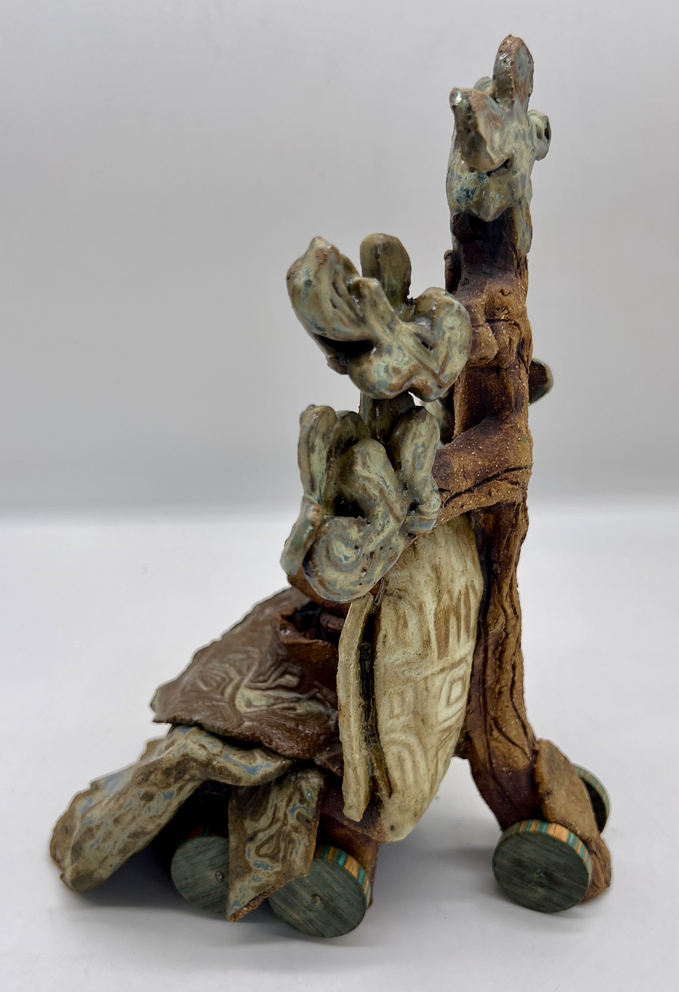 Engel. Side/Back view. Ceramic Sculpture. 2025. The Sage Elders. These are the old ones with a comfort blanket and wheelchair. They are the Librarians of all Oak knowledge.