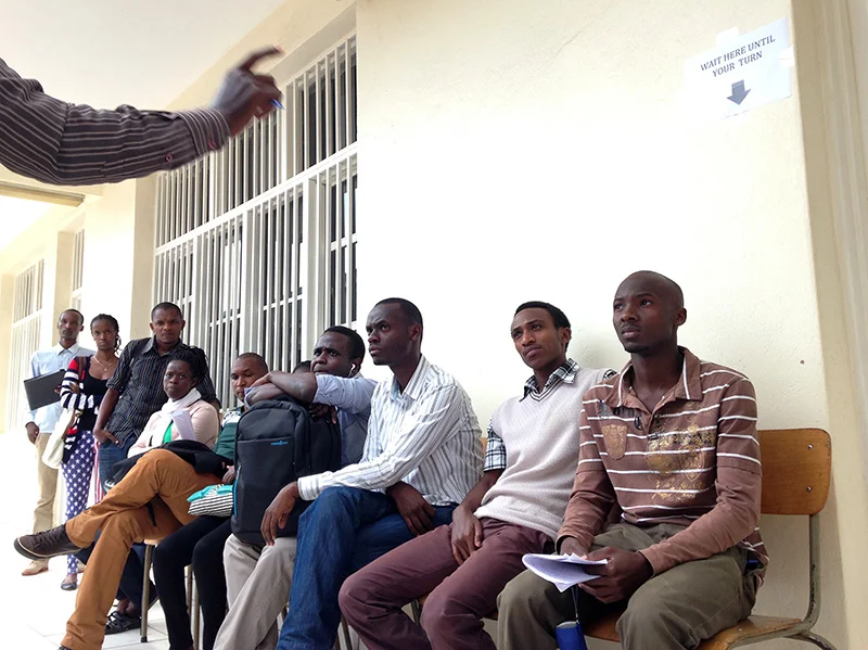 New students listen to Seth Mushimiyimana, a current student, explain the registration and ID pick-up process.