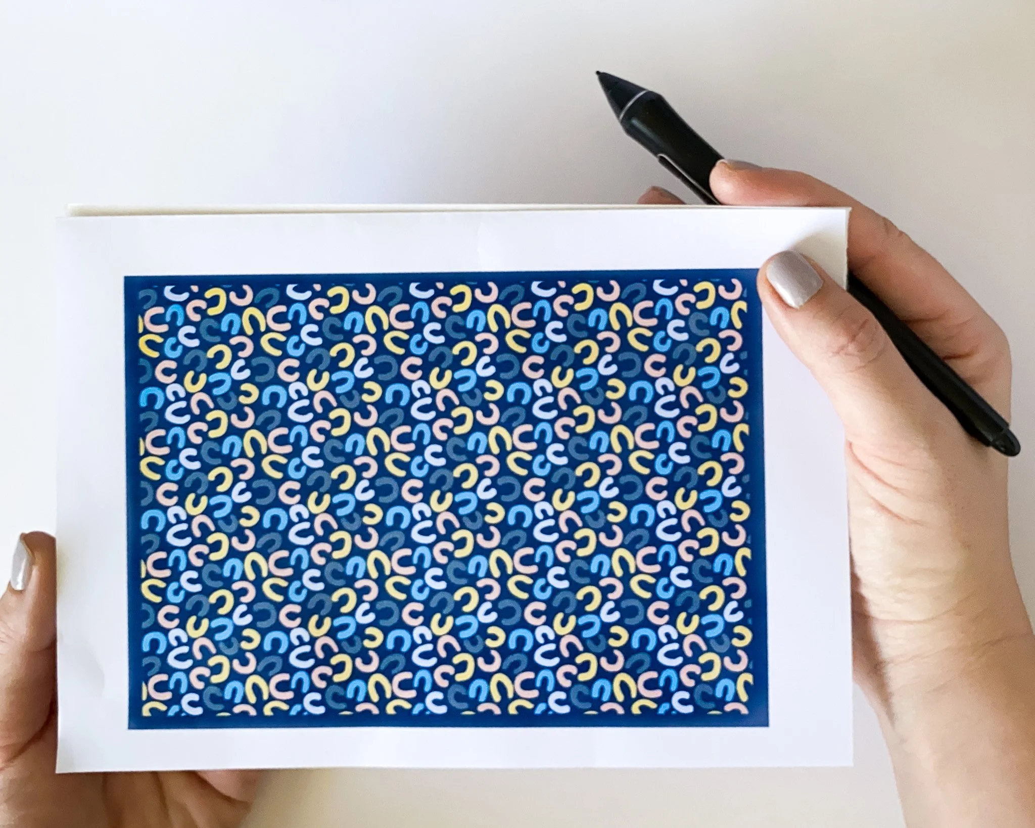 repeat pattern sample with small abstract motif in pastel on dark blue background made in illustrator for surface pattern design applications