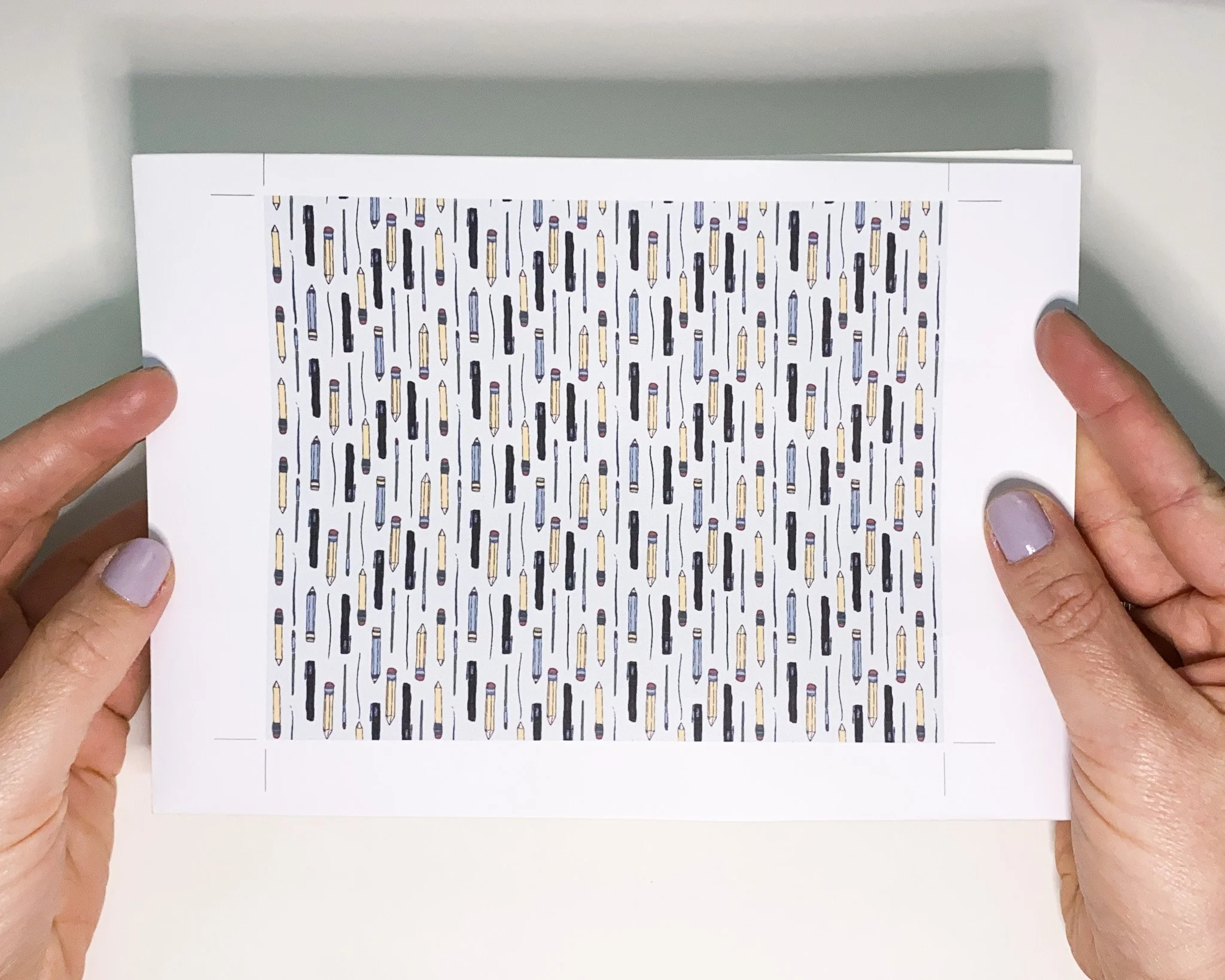 Printed drawing tools repeat pattern sample held in hand, hand-drawn digital arrangement surface design