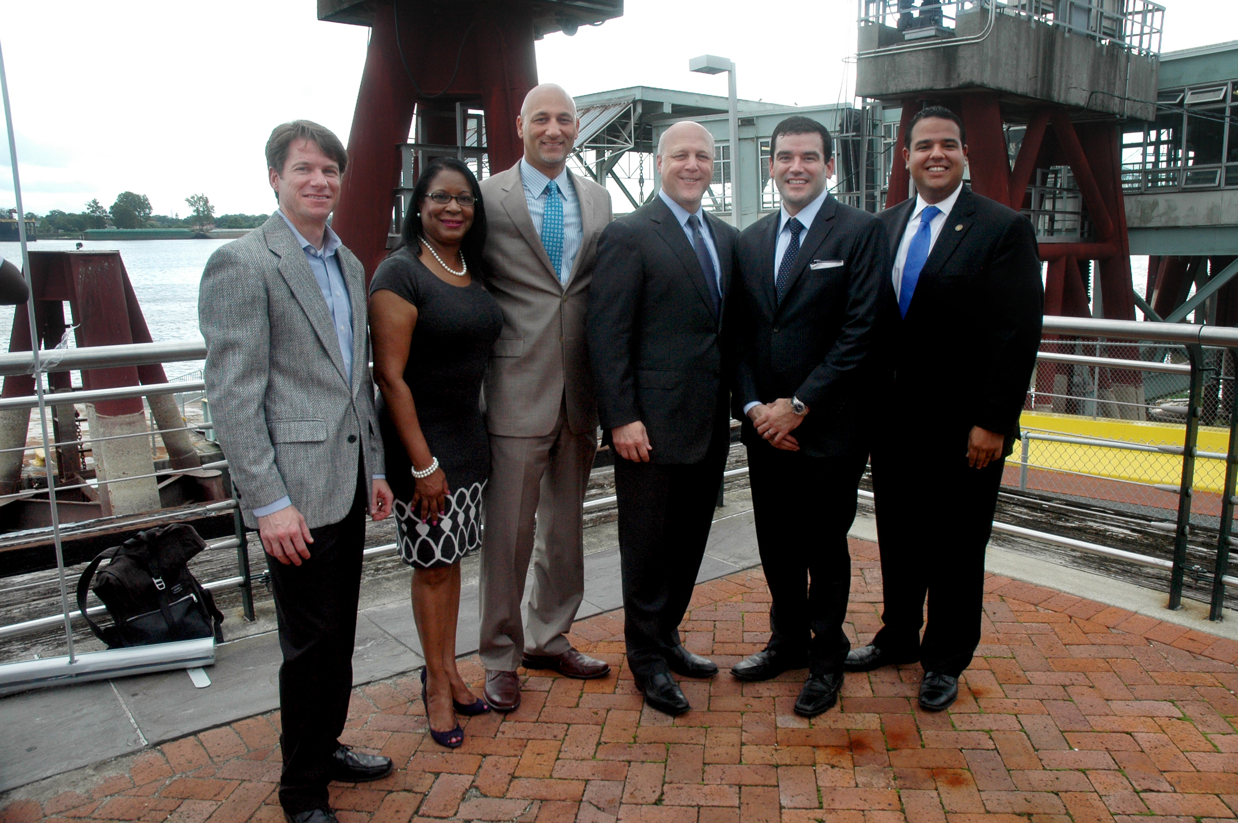 Infinity Engineering Consultants principal partners and city officials gather in front of the old Canal Street Ferry Terminal after the announcement of the plans of a new terminal. From left, Infinity Principal Bill Thomassie; District "C" Councilmember Nadine Ramsey; Infinity Principal Raoul V. Chauvin, III; City of New Orleans Mayor Mitch Landrieu; Assistant Secretary of Transportation Policy Carlos Monje Jr.; and District "B" Councilmember Jared Brossett. 