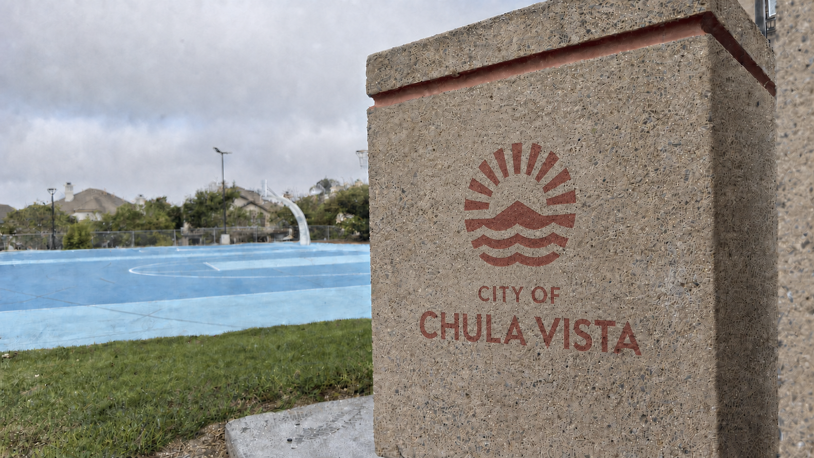 Image of the City of Chula Vista logo on a concrete trash can in a terracotta color.
