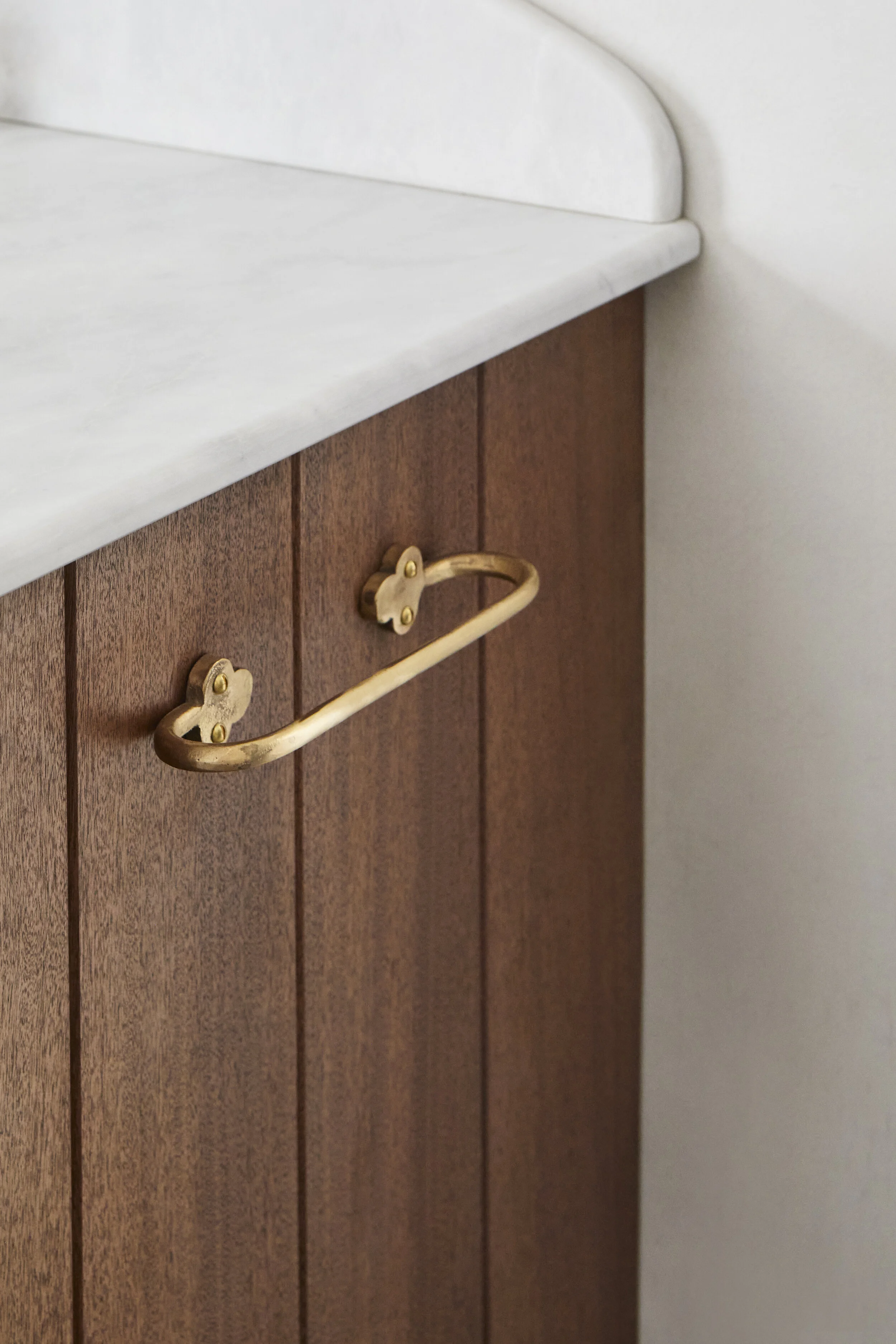 Hand Towel Rail, Cast Bronze close-up of towel rail fixed to the side of a timber T&G basin unit with marble surface. Made in raw bronze.