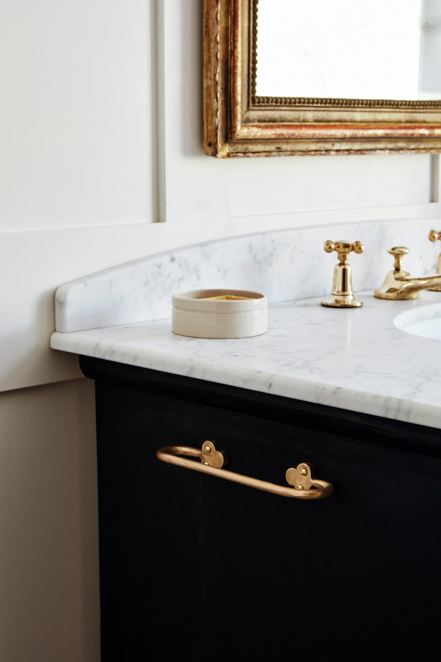 Hand Towel Rail, Cast Bronze rail fixed to side of black antique painted basin unit with marble, featuring brass basin taps and a stoneware soap pot on the marble surface. Made in raw bronze.