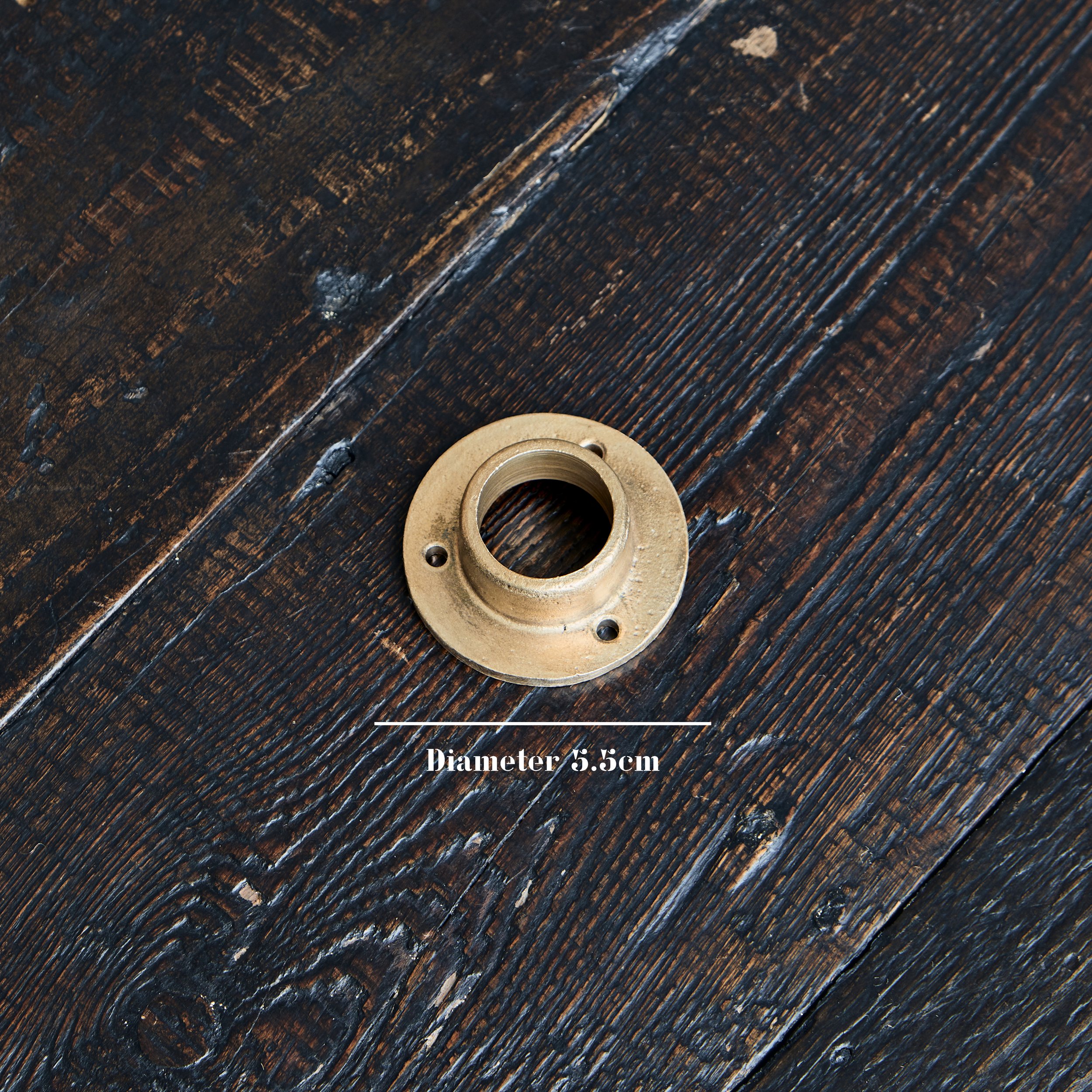 Wardrobe Rail Wall Socket close-up of bronze wall socket on timber board, showcasing the texture of sand-cast raw bronze. Text on photo shows wall side flange of socket is 5.5cm diameter.