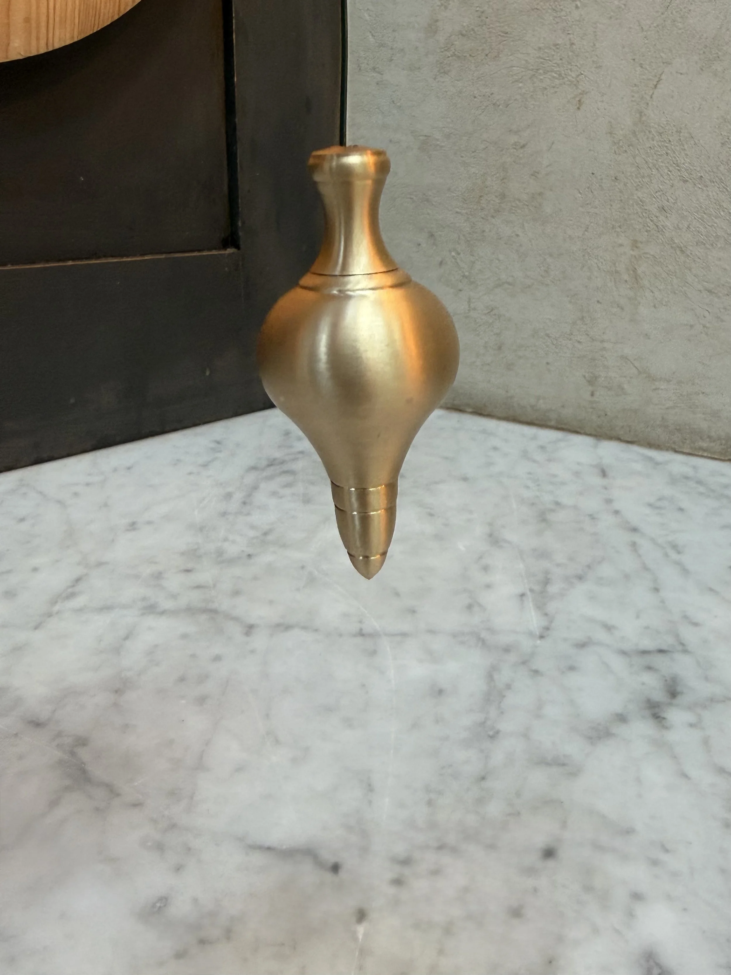 unlacquered-brass-cord-weight-marble-surface.jpg
