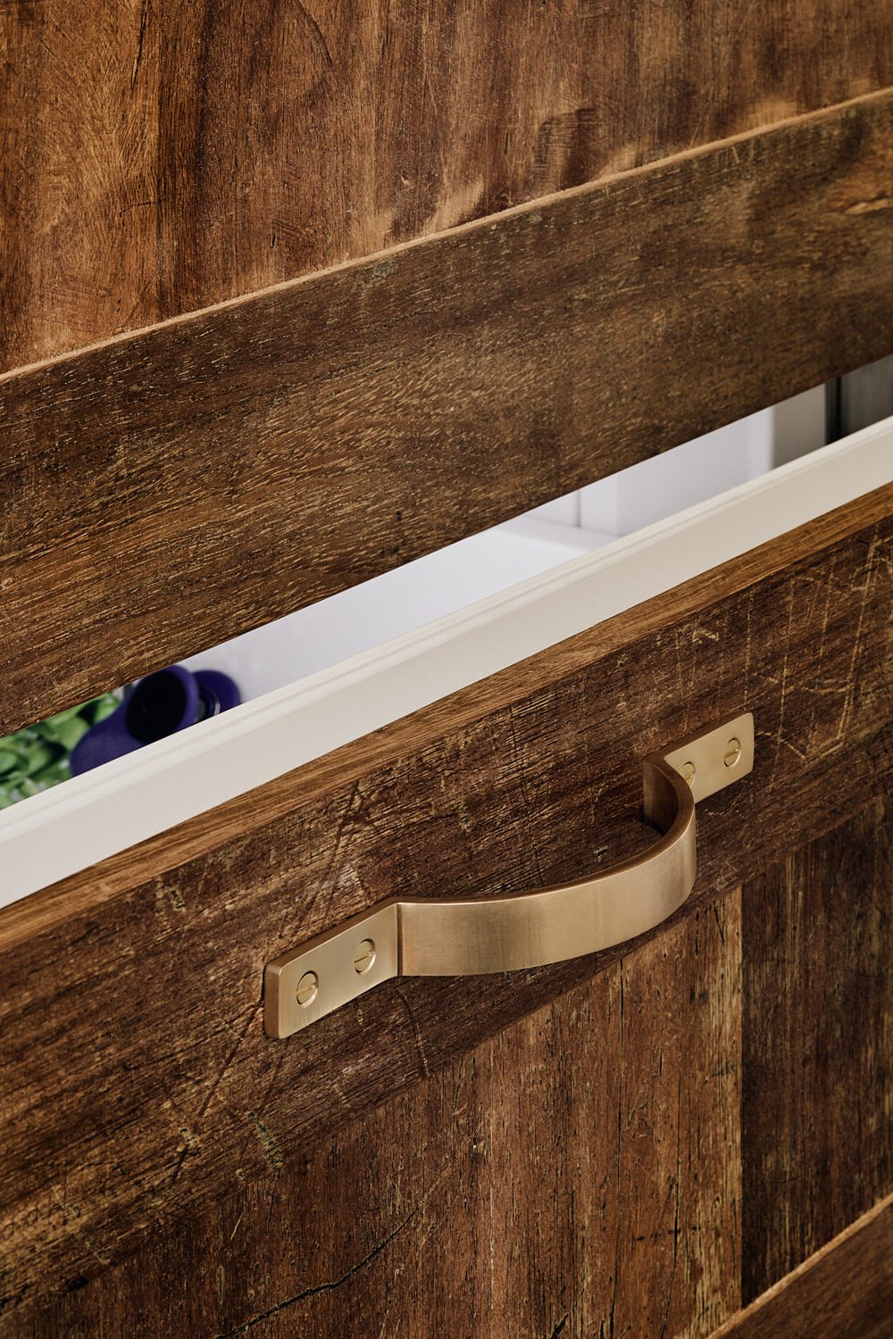 Moray kitchen pull fitted horizontally on an ajar Sub-Zero freezer drawer, set against aged iroko timber used for the drawer panel.