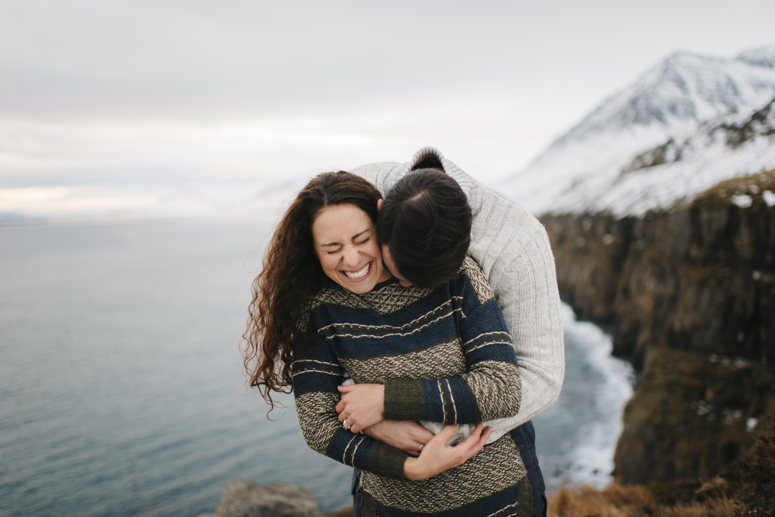 Cuddling couple by lake during Adventure Photography by Iceland Elopement Photographer Colby and Jess colbyandjess.com