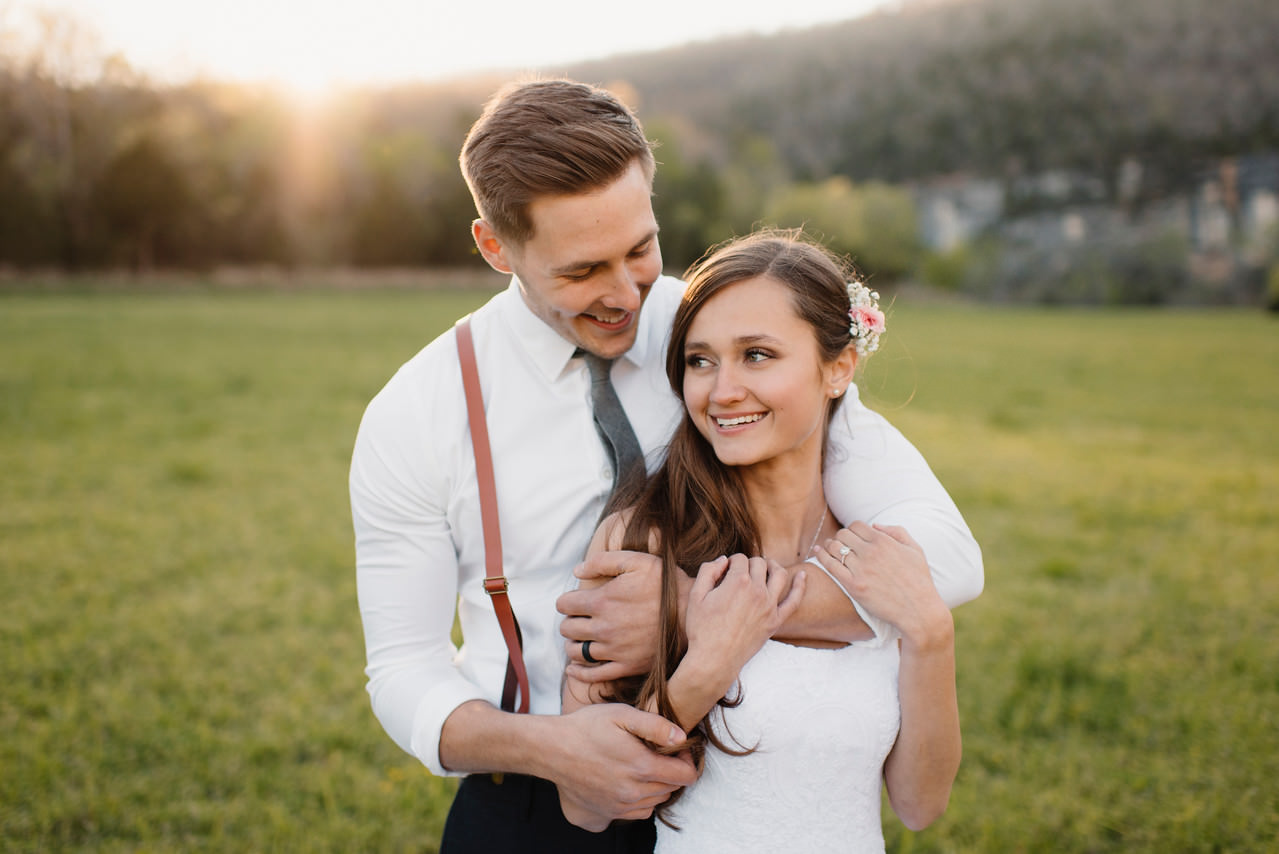 A groom holds his bride close after their Steele Creek Wedding at the Buffalo River with Arkansas Adventure Destination Photographer Colby and Jess