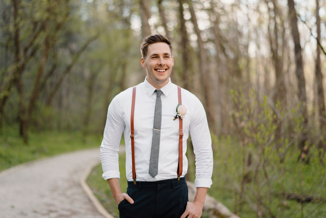 A groom stands in the woods before his Buffalo River Wedding with Arkansas Adventure Destination Photographer Colby and Jess