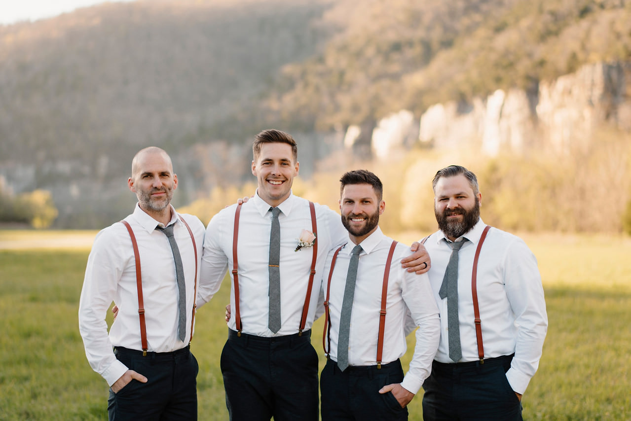 A groom stands with his groomsmen after his Steele Creek Buffalo River Wedding with Arkansas Adventure Destination Photographer Colby and Jess