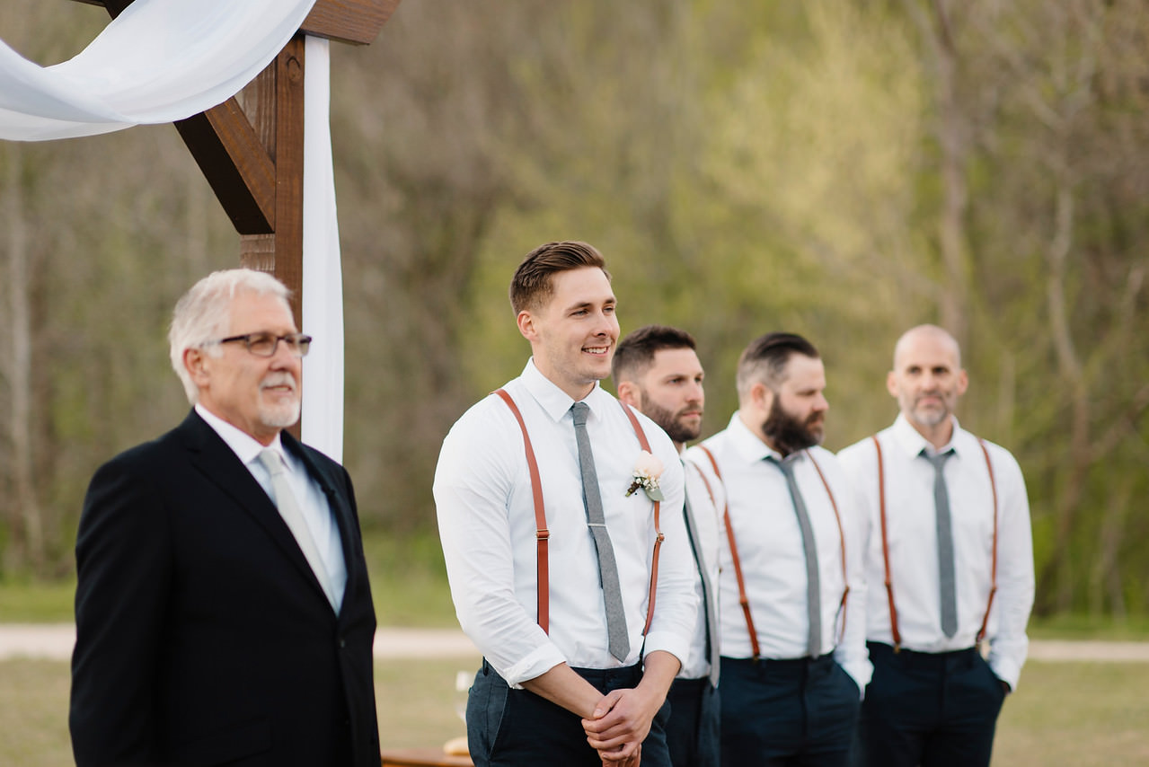 A groom watches his bride walk down the aisle during their Outdoor Buffalo River Wedding by Arkansas Adventure Destination Elopement Photographer Colby and Jess