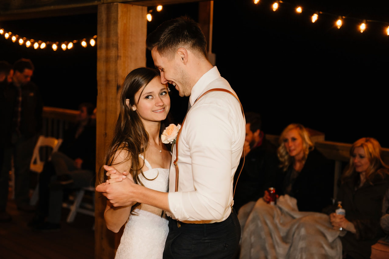 A bride smiles as she dances with her groom after being married at Steele Creek Buffalo River with Arkansas Adventure Destination Photographer Colby and Jess