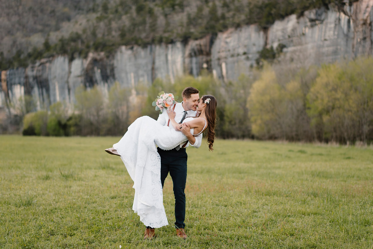 A groom picks up his bride at Steele Creek Buffalo River with Arkansas Adventure Destination Photographer Colby and Jess